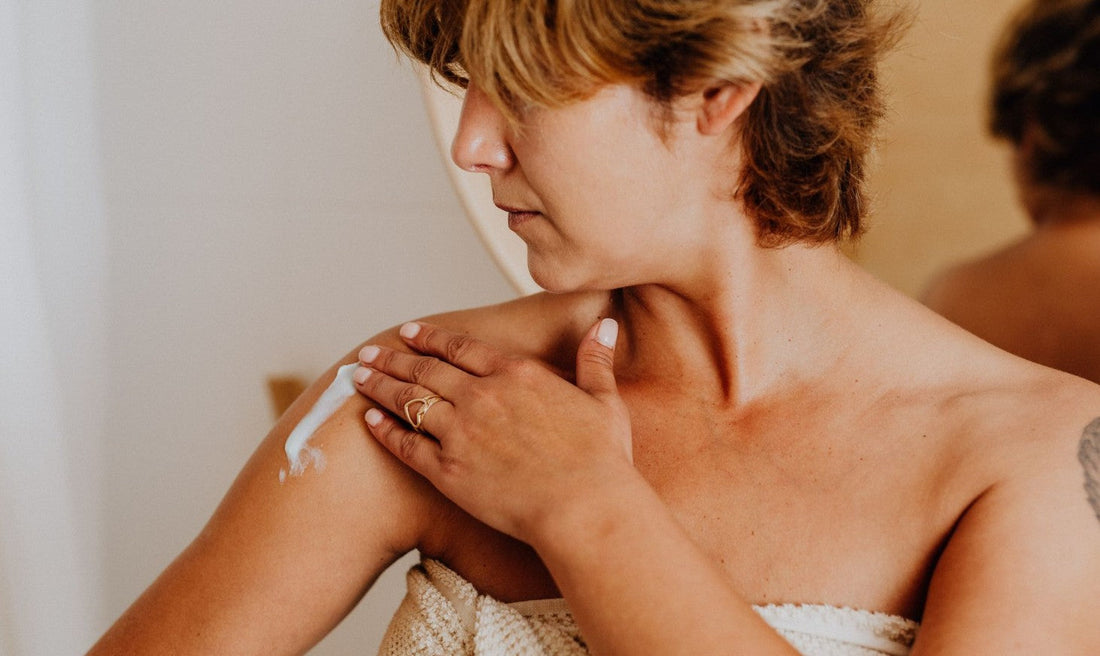 Woman applying lotion to arm during eczema flare — dairy is one of several possible food triggers for atopic dermatitis
