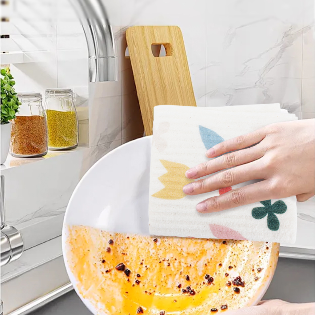 Person cleaning a plate with a colorful Gentle Cloth in a kitchen setting